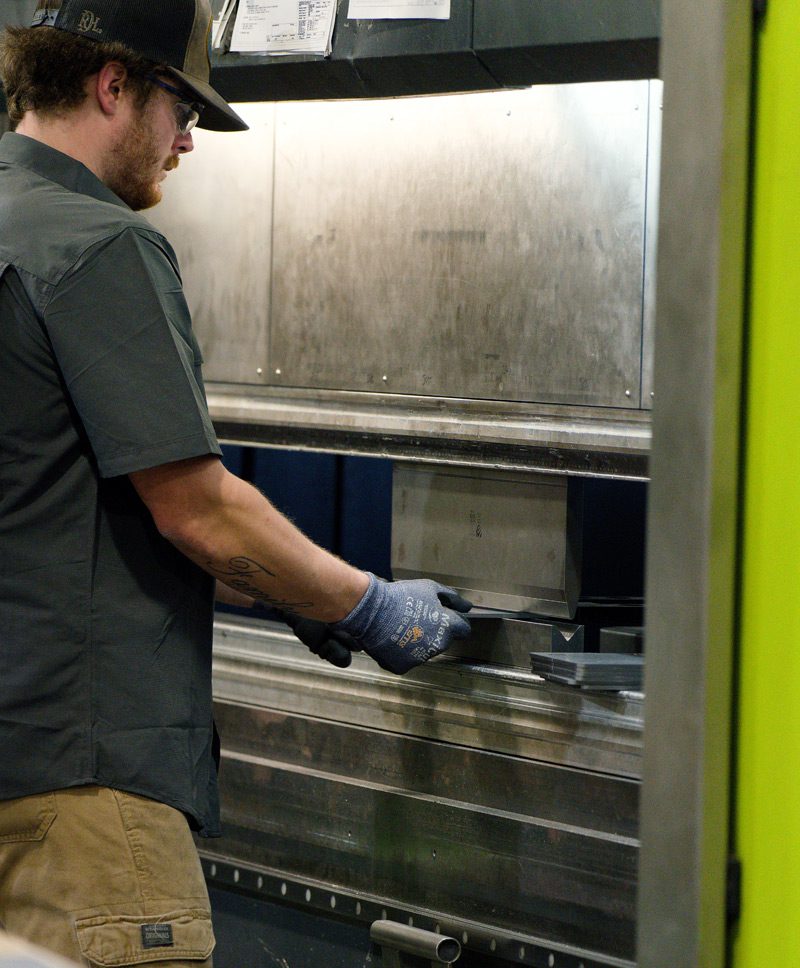 M3 employee operates the press brake machine