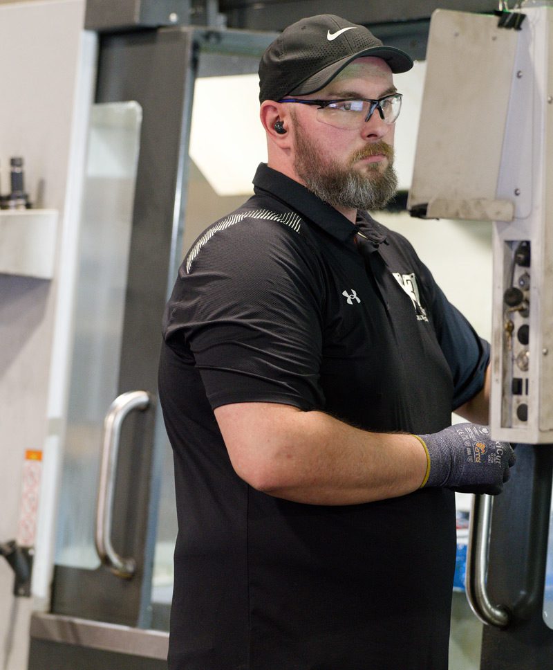 M3 employee operates CNC machinery during metal fabrication